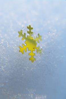 golden snowflakes on a real snowy icy surface