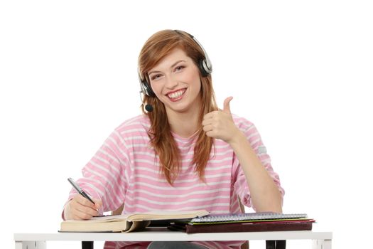 Teen girl learning at the desk (e-learning concept), isolated on white