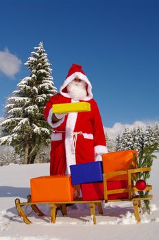 Santa Claus, Father Christmas with colorful presents on a sledge