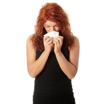 Woman holding tissue and sneezing isolated on white background