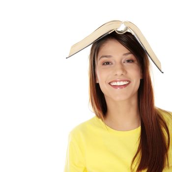 Beautiful young caucasian woman with book on her head