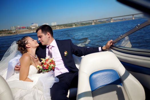 bride and groom kissing on the boat