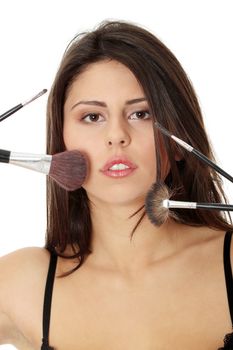 Young beautiful woman face with make up brushes, isoalted on white