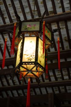 An traditional chinese lantern hanging on roof of house