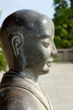 Stone sculpture depicting side face of holy buddha