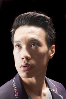 closeup of a young asian man on a black background