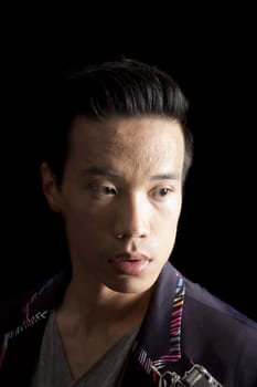 closeup of a young asian man on a black background