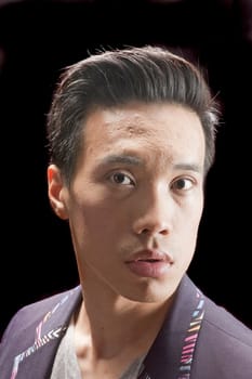 closeup of a young asian man on a black background