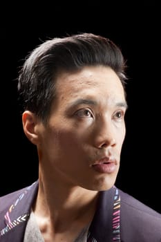 closeup of a young asian man on a black background