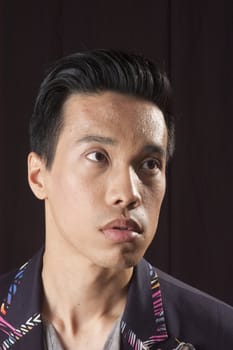 closeup of a young asian man on a black background