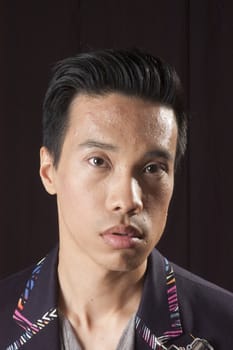 closeup of a young asian man on a black background