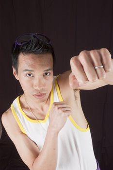 closeup of a young asian man on a black background in boxing stance from above