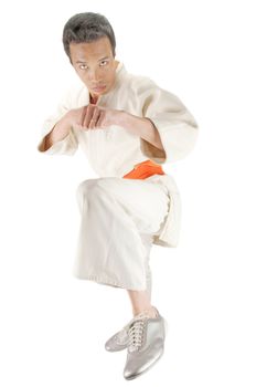 Young asian man in an Aikido, judo, Karate outfit kicking towards the camera isolated on a white background