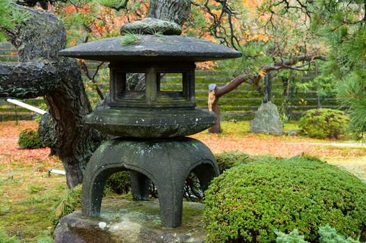 Granite lantern in the middle of wild garden