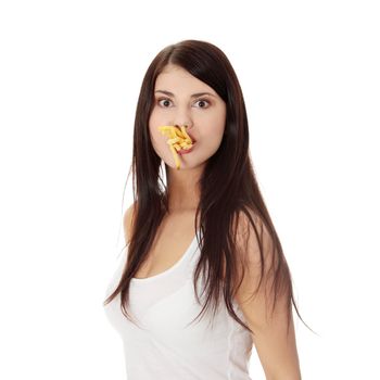 Young woman eating fries against a white background