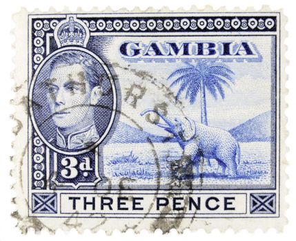 Gambia - Circa 1950 : A vintage Gambian postage stamp image of an elephant beside a palm tree and inset of King George, and a face value of 3 pence, series circa 1950