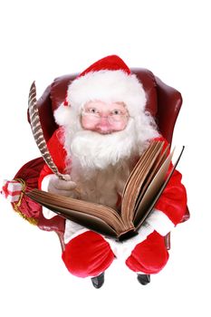 Closeup of Santa Claus (that jolly old elf that  lives at the North Pole) reading and writing in the book of good children, taken with a fish eye lens for added humor