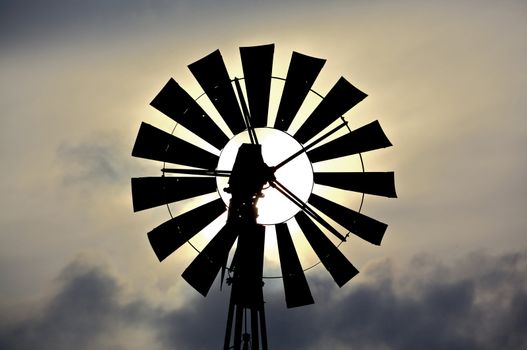 Silhouette of an old fashioned windmill against cloudy sky