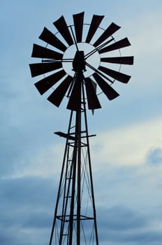 Silhouette of an old fashioned windmill against cloudy sky