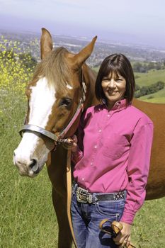 Closeup of attractive woman trainer with her horse