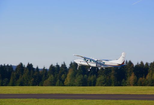 Small skydive equipped airplane lifting off