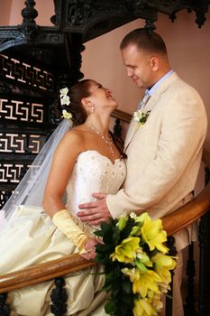 The beautiful bride and groom on a pig-iron ladder