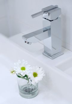 Closeup of modern bathroom tap with flower