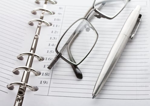 close-up notebook, pen and glasses