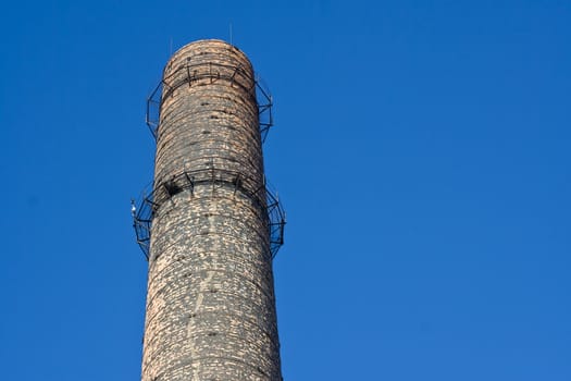 Old chimney-stalk on a background blue sky