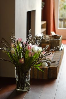 Part of interior with fireplace and bouquet of springflowers - vertical