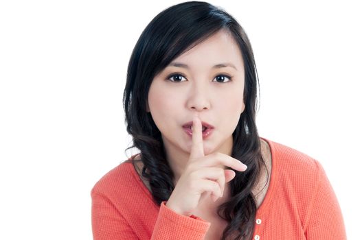 Portrait of a beautiful young woman with finger over her lips, isolated on white background.