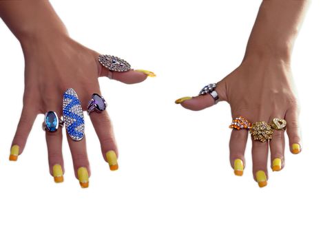 Hand showing big rings on fingers, colored nails