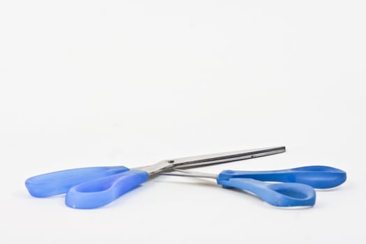 Two pairs of different size scissors on a white background.