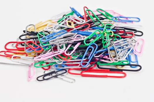 a plie of colored paper clips on a white background