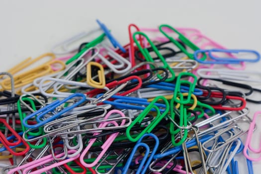 a plie of colored paper clips on a white background