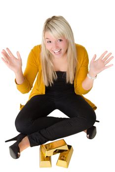 Young happy girl with goldbars sitting on the floor with hands in the air. Over white background