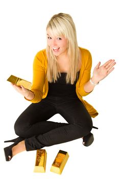 Young happy girl with goldbars sitting on the floor with hands in the air. Over white background