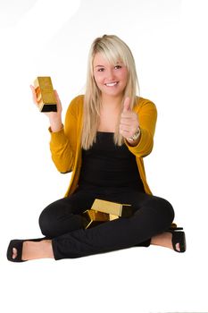 Young happy girl with goldbars sitting on the floor giving thumbs up Over white background