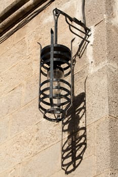 Old street lamp and its shadow in Ippoton (Street of the Knights) in Old Town Rhodes (Greece), a World Heritage Site.