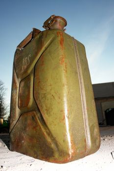 a green jerry can on concrete floer.