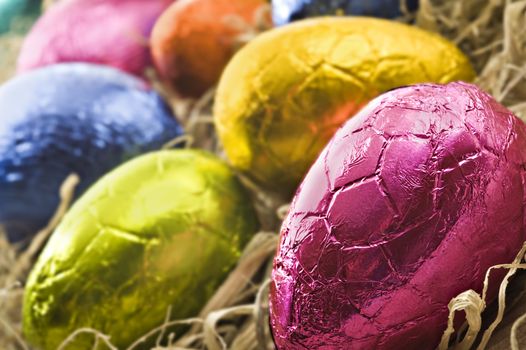 Colorful easter eggs in straw - close up with shallow depth of field