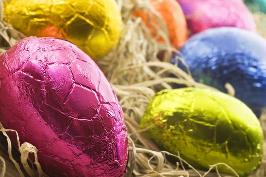 Colorful easter eggs in straw - close up with shallow depth of field