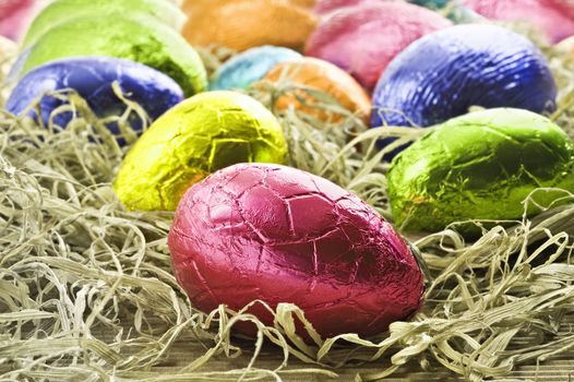Colorful easter eggs in straw - close up with shallow depth of field