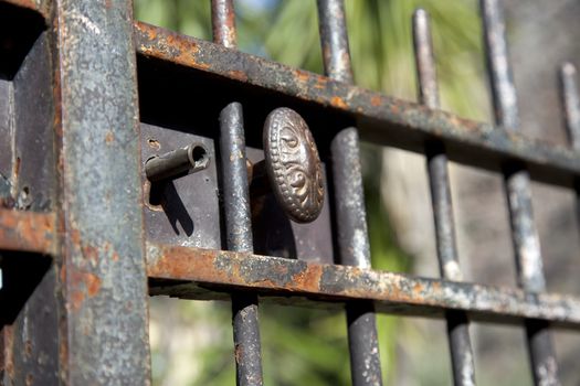 Doorknob and keyhole on a metal gate.