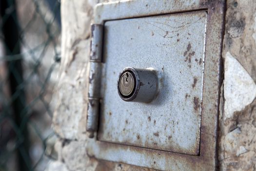 Keyhole for lock box in stone wall.
