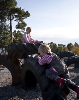 Small children climbing on tyres