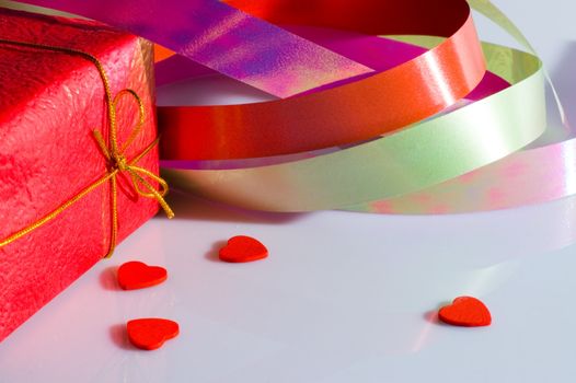 The present box, multicolored ribbon and some small hearts