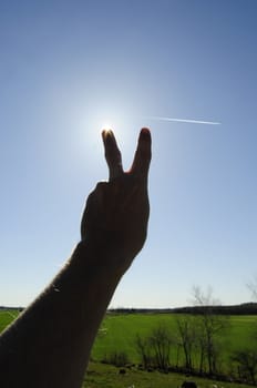 the victory gesture against strong sun
