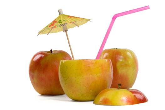 Apples with umbrella and straw on white background
