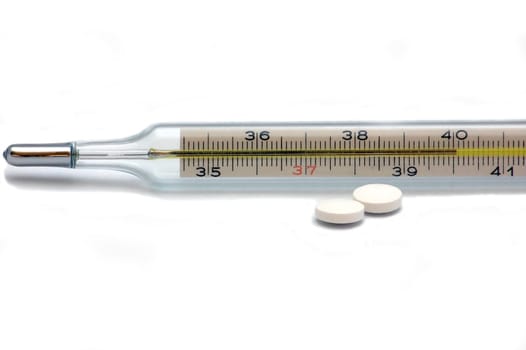 thermometer and white pills isolated on the white background